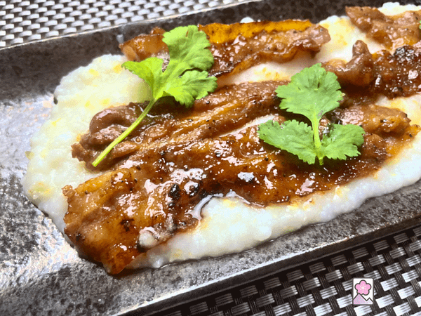 Savory succulent Homemade Bacon is served over Hominy Grits and topped with some fresh coriander