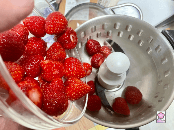 Strawberries being put into a food processor