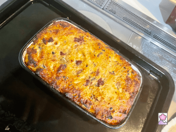 Baked Leftover Turkey and Stuffing loaf with a crispy top, cooking in a pan