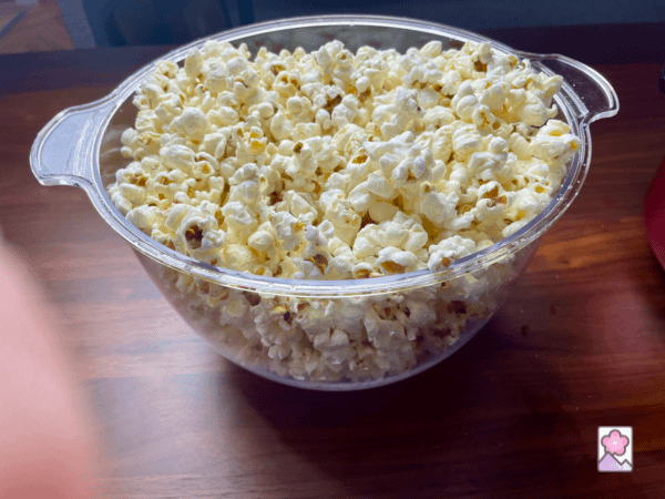 A glass bowl full of freshly popped popcorn