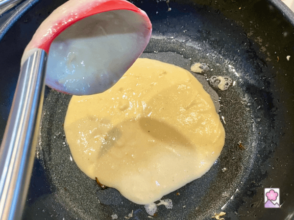 Spooning vichyssoise potato pancake batter into a hot skillet