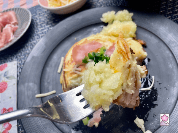 A fork full of vichyssoise potato pancake and homemade applesauce