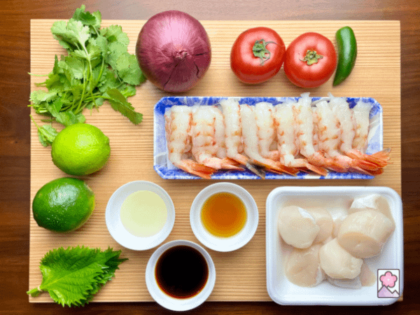 Japanese Shrimp and Scallop Ceviche ingredients on a board include seafood, veggies, herbs and seasoning