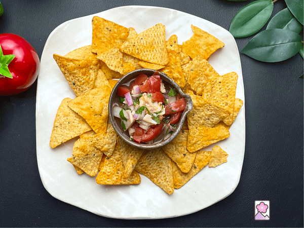 Japanese Shrimp and Scallop Ceviche in a clay bowl sitting on a plate surround by tortilla chips