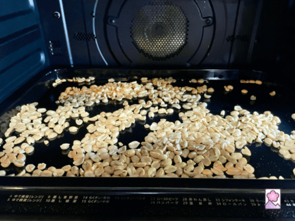 Peanuts are roasting on a cookie sheet in the oven