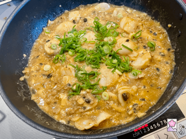 Scallops with Lobster Sauce in the Wok and garnished with scallions