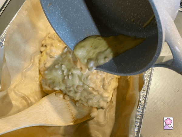 Pouring the hot brittle out onto a pan lined with parchment paper