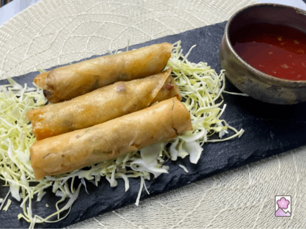 3 Harumaki served over shredded cabbage with sweet chili sauce on the side
