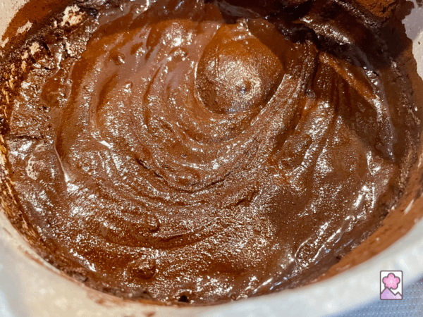 Creamy chocolate melted over heat in a saucepan swirling around
