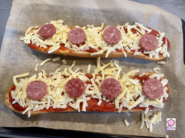 Bread topped with ingredients on parchment paper