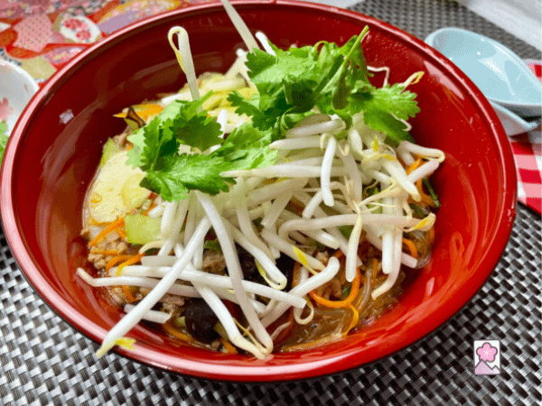 Pork Beefun and Tteok topped with corriander and bean sprouts in a Chinese bowl