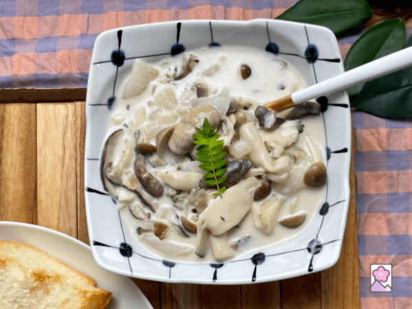 Mushroom Fricassée in a ceramic bowl. A serving spoon is in the bowl.