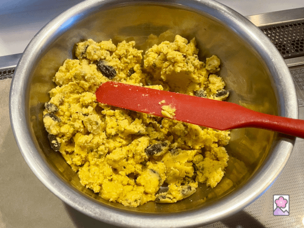 Mixing nuts and raisins into the batter in a metal bowl