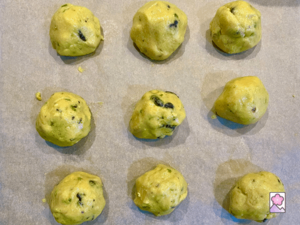 Nine Laddus cooling on a sheet of parchment paper