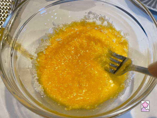 Mixing the egg yolk, lemon, lemon zest and cheese to make a creamy sauce