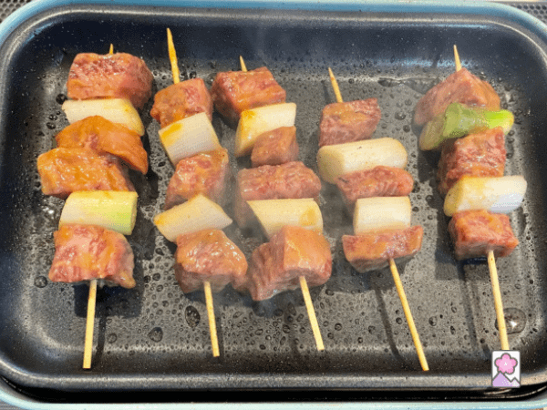 Cooking the skewers on a Japanese hot plate