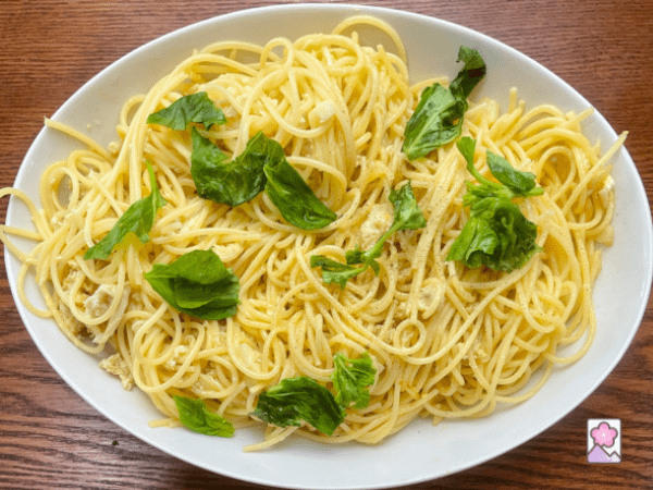 A large bowl of Lemony Crabmeat Pasta topped with fresh basis