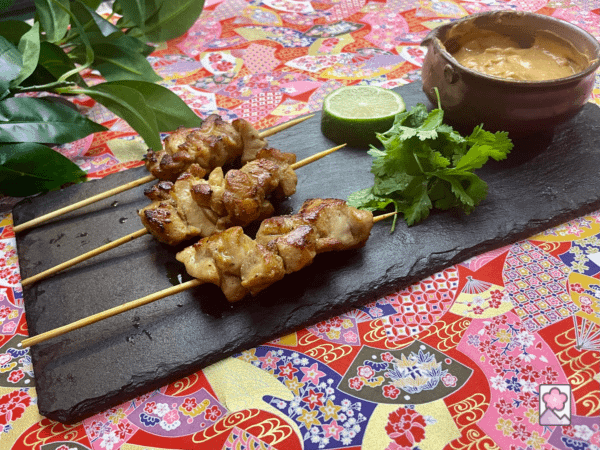 3 sumptuous juicy thai chicken skewers with peanut sauce served with cilantro and lime