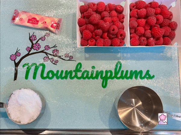 All natural ingredients for homemade raspberry gelatin on a glass Mountainplums cutting board