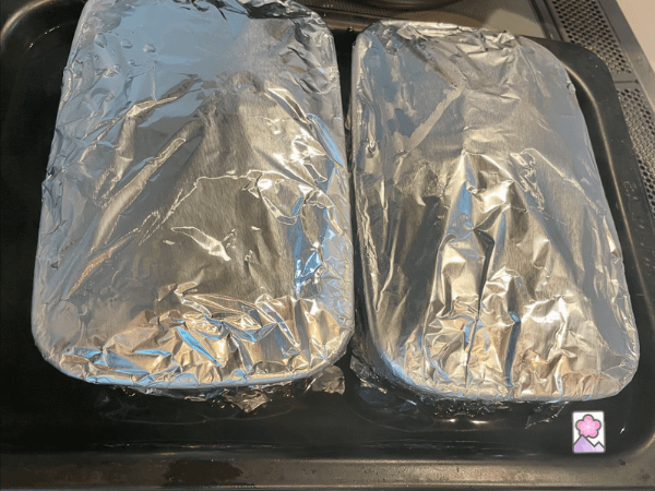 Terrines covered in foil in a water bath