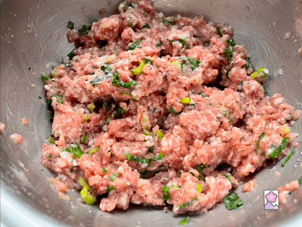 Pork mixed with other ingredients before forming meatballs