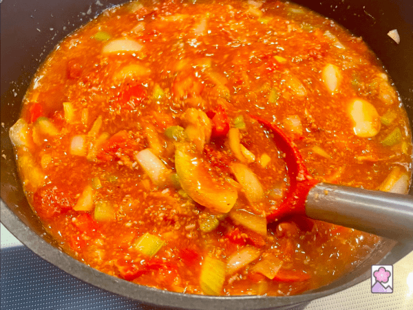 Chili Ingredients combined in a stockpot and stirred with a large spoon