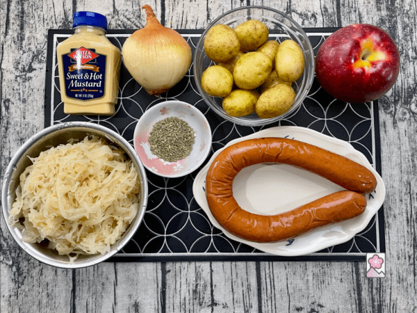 Ingredients for Polish Kielbasa and Sauerkraut Skillet laid out on a board (olive oil not shown)