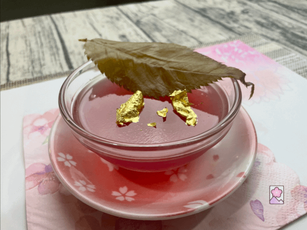 Sakura gelatin is served in a brown and garnished with Sakura leaf and edible gold
