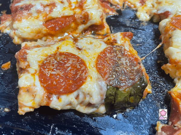 Ooey, Gooey pizza ready to eat. Pepperoni and Cheese along with basil drip from the crust.