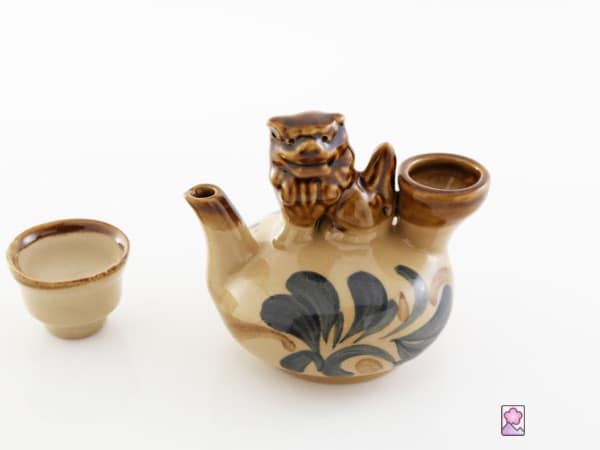 Awamori served in a traditional ceramic pitcher decorated with a shisa lion