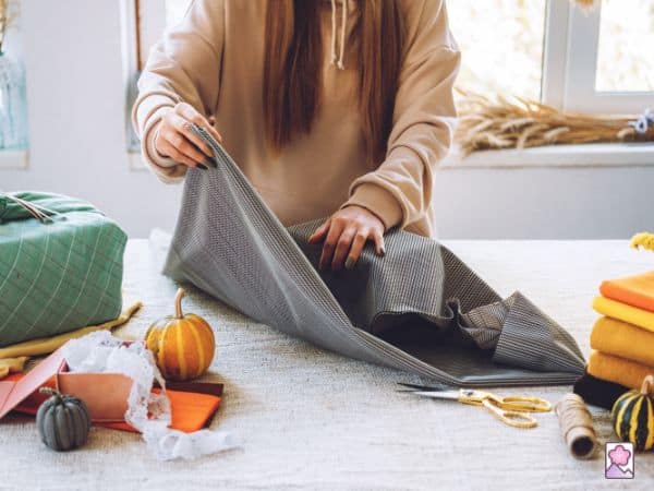 A woman wraps a gift using traditional Japanese paper