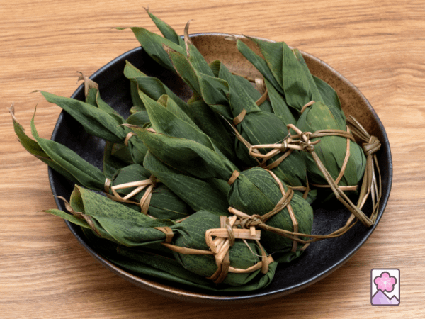 Sasa Dango wrapped in green leaves in a bowl