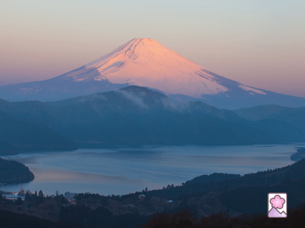 Lake Ashi is in the foreground with a snow covered Mount Fuji in the background