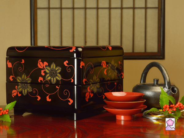 A jubako is a lacquered, multi layer bento box. This is a two layered box with some lacquered bowls in the foreground.