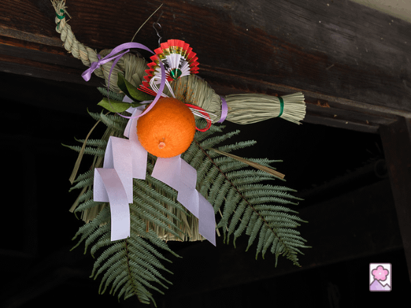 A shimekazari wreath hangs in a doorway