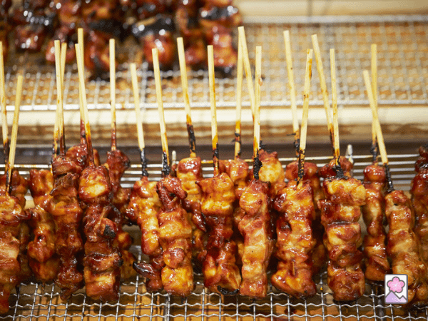 Many sticks of Yakitori on metal grille racks