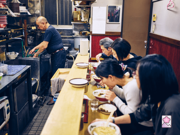 Customer eating ramen sitting at a counter