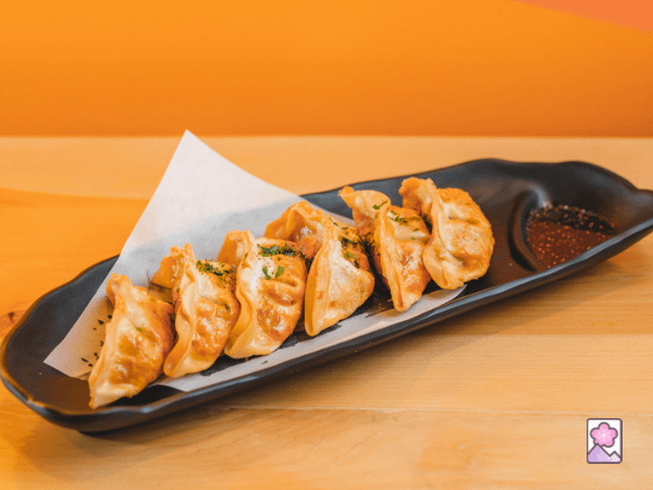 Gyoza served on a long plate with space on the righthand side
