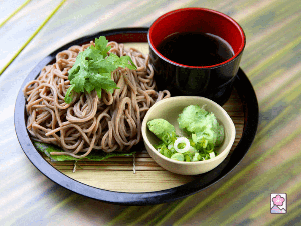 Cold dipping noodles - zaru soba, on a plate with scallions and dipping sauce