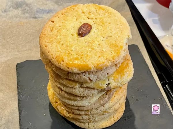 A stack of Chinese Almond Cookies sits on a square slate plate