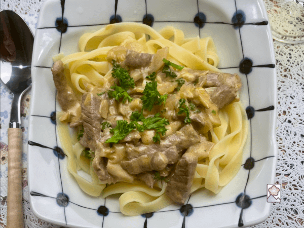 Wagyu Stroganoff on pasta topped with parsley